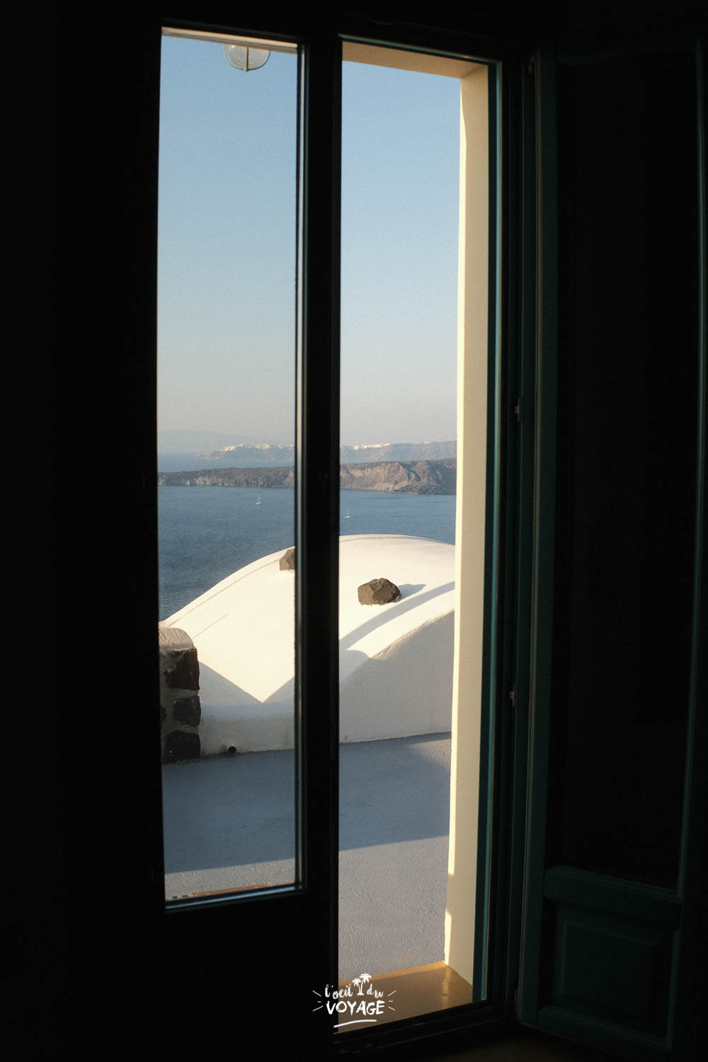 Photographie de voyage minimaliste, par la fenêtre, à Santorin.